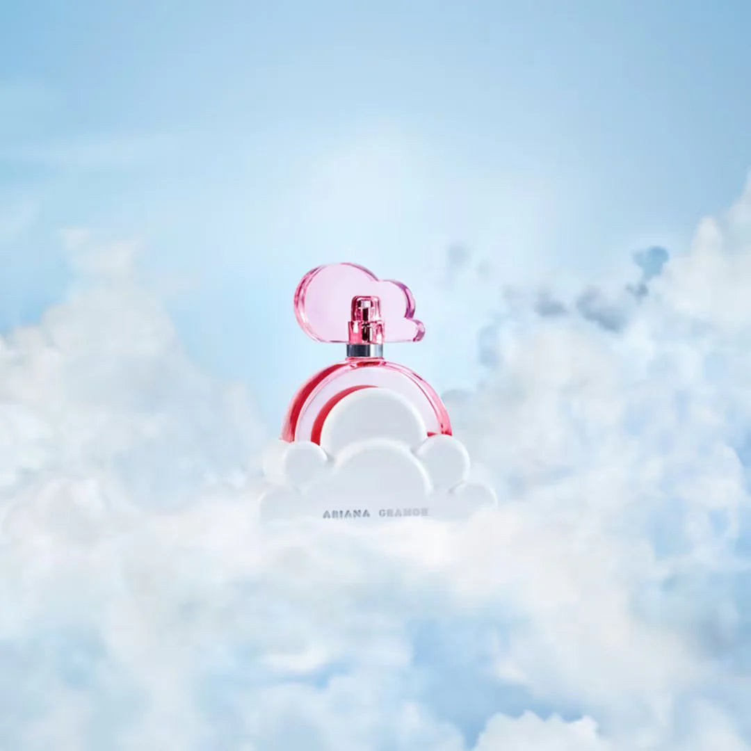 Pink cloud-shaped perfume bottle against a blue sky with white clouds