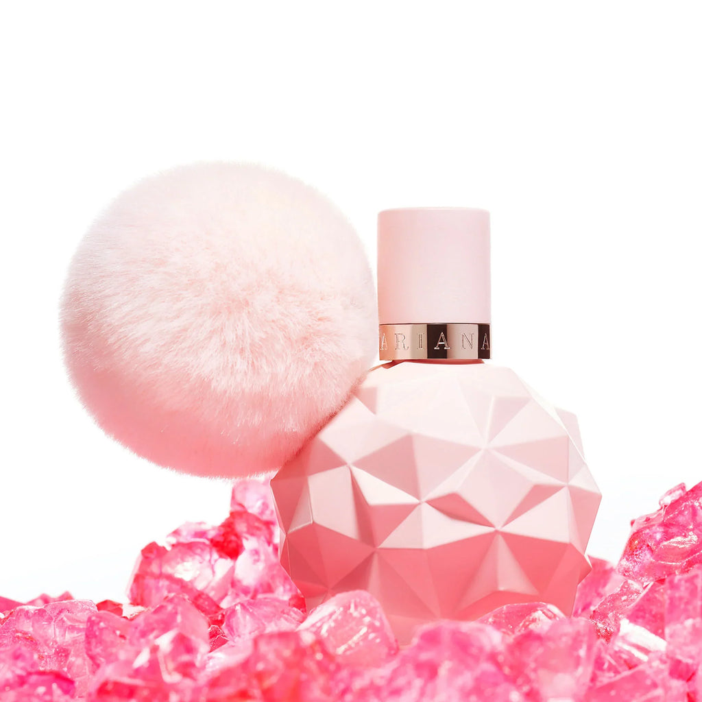 Pink perfume bottle with geometric design on a white background