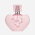 Pink heart-shaped perfume bottle with 'Ariana Grande' branding on a light gray background