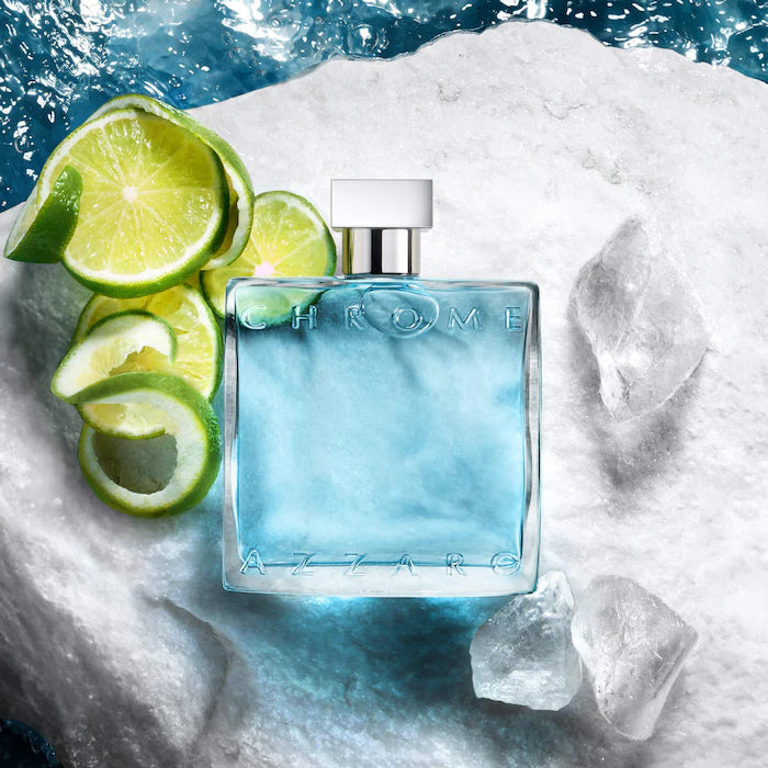 Blue Azzaro Chrome perfume bottle with lime slices on a snowy background